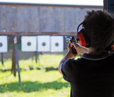 young-boy-concentrates-while-shooting-from-revolver-shooting-range young-boy-concentrates-while-shooting-from-revolver-shooting-range